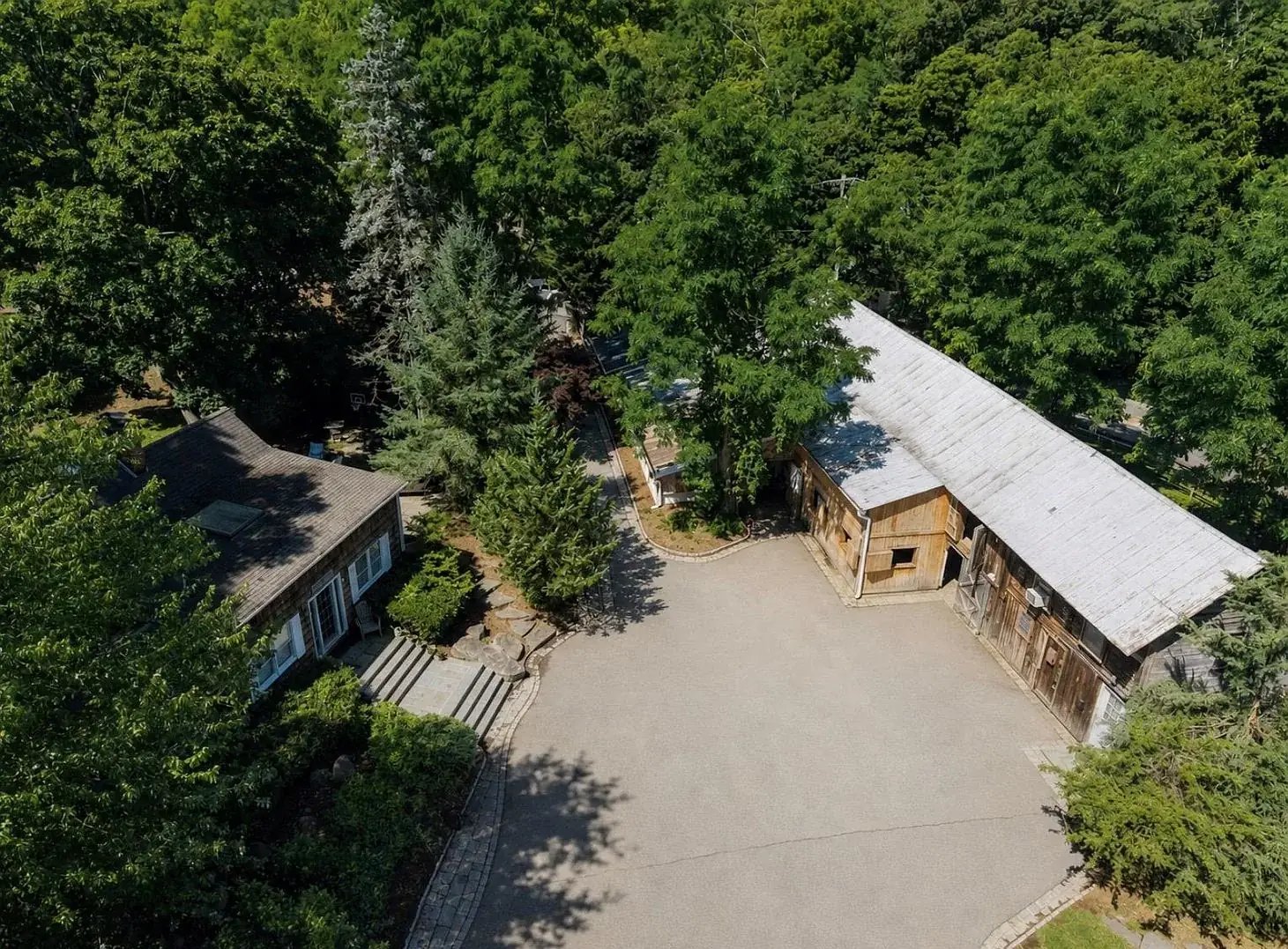 Aerial view of the barn roofline and arena among the trees